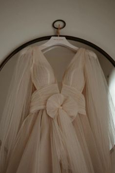 a dress hanging on a hanger in front of a mirror