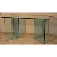 two glass tables sitting next to each other on top of a hard wood floored floor