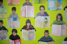 a group of children holding books in front of a green wall