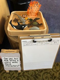 there are two boxes with fake sea animals in them and a sign that says can you tell and write these letters?