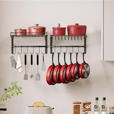 pots and pans are hanging on the wall in a kitchen with utensils