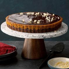 there is a cake on the table with toppings next to it and a bowl