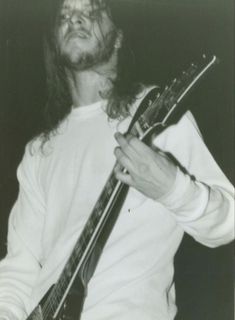 a man with long hair holding a guitar