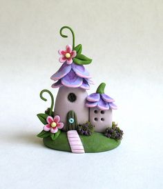 a small toy house with flowers on the roof