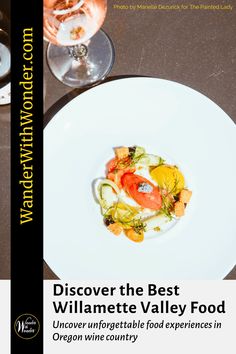 a white plate topped with food on top of a table next to two wine glasses