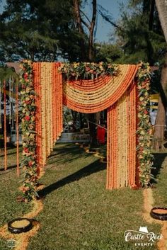 an orange and yellow wedding arch decorated with flowers