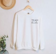 Team Bride Sweatshirts 🕊️🤍✨ Team Bride Sweatshirt, White Crew Neck Top For Bridesmaids, Relaxed Fit Crew Neck Top For Bachelorette Party, Cotton Crew Neck T-shirt For Hen Party, White Crew Neck Top For Bridal Shower, Bride Sweatshirt, Sweat Shirts, Bride Tribe, Team Bride