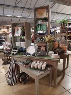 a table with plates and cups on it in a store