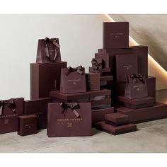 many brown boxes with bows are stacked on top of each other in front of a white wall