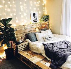 a bed made out of pallets with lights on the wall