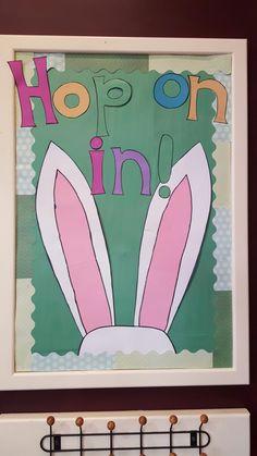 an image of a rabbit with the words hop on in it's ears hanging from a coat rack