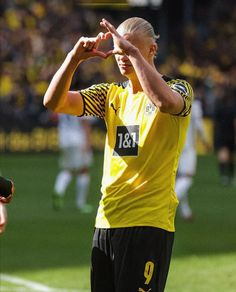 a soccer player saluting the crowd with his hands