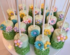 there are many cake pops decorated with flowers on the top and candles in the middle