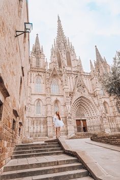 a woman is standing on some steps in front of a building