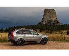 an suv parked in front of a large rock formation