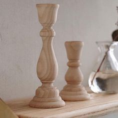 three wooden candlesticks sitting on top of a shelf