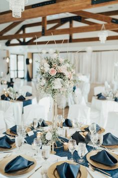 a table set with blue napkins and gold place settings