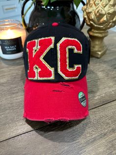 One of a kind black and red distressed hat with red and gold chenille letters. One size fits most. Red Letter Print Hat For Baseball Season, Black Baseball Cap With Letter Print For Game Day, Black Trucker Hat With Letter Patch For Streetwear, Black Trucker Hat With Letter Print For Game Day, Black Hat With Letter Patch, Black Snapback Hat With Letter Patch, Trendy Distressed Black Baseball Cap, Novelty Black Trucker Hat With Letter Print, Distressed Black Snapback Hat