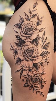 a woman's thigh with roses and leaves tattoo on the side of her thighs