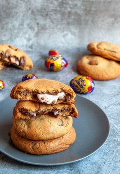 chocolate chip cookies stacked on top of each other with candy eggs in the back ground