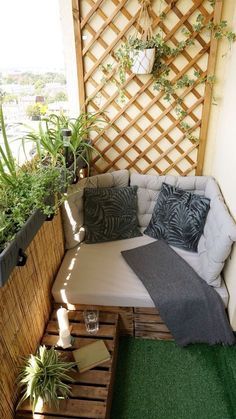 an outdoor seating area made out of pallets and wooden crates with plants on top