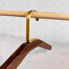 a wooden coat rack with two hooks on it's sides and a metal bar at the top