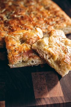 two pieces of bread sitting on top of a wooden cutting board next to each other