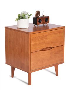 a wooden cabinet with a radio on top and a potted plant next to it