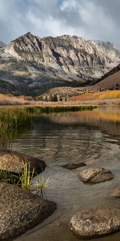 some rocks in the water and mountains