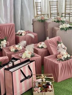 pink and white bags with flowers on them are sitting in the grass next to each other