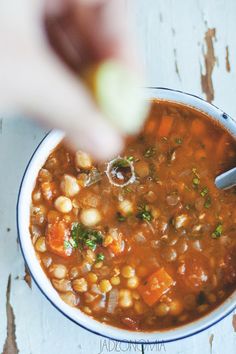 a bowl of beans and carrots with a spoon in it