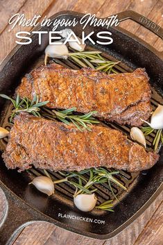 steaks cooking in a cast iron skillet with garlic and herbs on the side