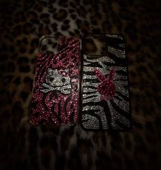 two cell phones covered in pink and silver sequins on a leopard print background