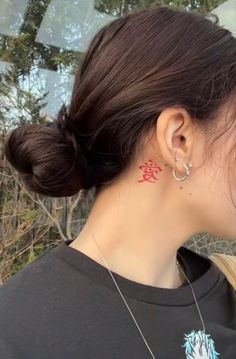 a woman with tattoos on her neck and behind her ear