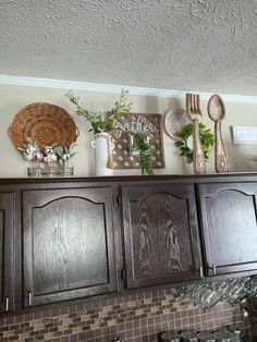 a kitchen with wooden cabinets and decorative items on top