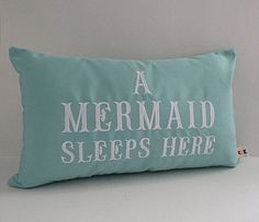 a mermaid pillow with the words, a mermaid sleeps here on it's side