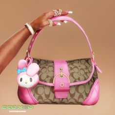 a woman's hand holding a hello kitty purse