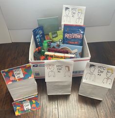 a box filled with lots of different items on top of a wooden floor next to paper bags