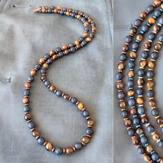 Introducing the "Eye of the Tiger" men's beaded necklace, a striking piece that combines the rugged elegance of natural stones with the bold style you seek. This necklace is meticulously handcrafted, featuring a powerful trio of Tiger Eye, Lava, and Hematite stones, each bead measuring a perfect 6mm. The Stones: Tiger Eye: Known for its captivating golden to reddish-brown hues, Tiger Eye is a stone of protection and grounding. It brings sharpness to one's inner vision and aids in manifesting wil Black Ninja, Tiger Eye Necklace, Mens Beaded Necklaces, Eye Of The Tiger, Brown Necklace, Beaded Jewels, Hematite Stone, Bold Style, Men Jewelry