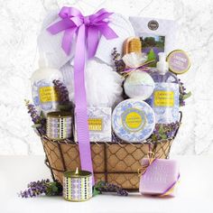 a basket filled with lots of different types of soap and lotion bottles next to a candle