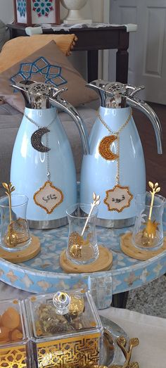 two blue tea kettles sitting on top of a table with other items around it