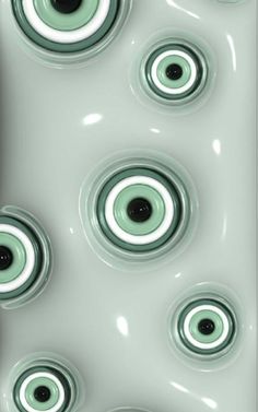 an abstract painting with green and black circles on white paper, in the shape of eyeballs