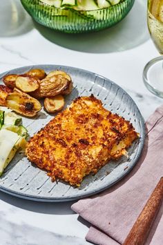 a plate with some food on it next to other plates and glasses filled with wine