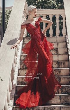 a woman in a red dress standing on some stairs