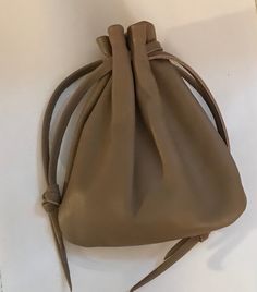 a brown leather purse sitting on top of a white table