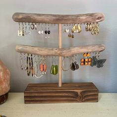 a wooden tree with earrings hanging from it's sides on top of a table