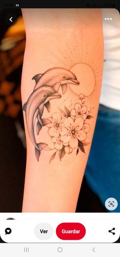 a dolphin and flowers tattoo on the arm