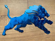 a blue metal lion sitting on top of a wooden floor