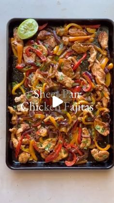 chicken fajitas with peppers and limes in a black casserole dish