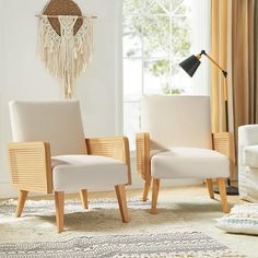 two white chairs sitting next to each other on top of a rug in a living room